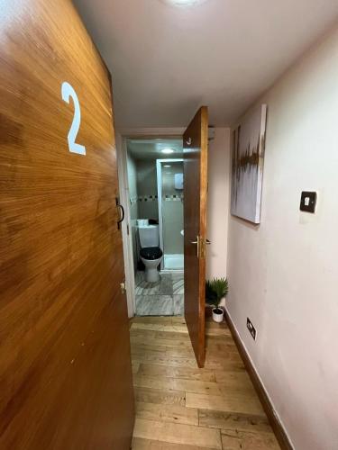 a hallway with a door to a bathroom with a toilet at Electric Eve in London