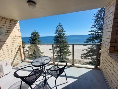 a balcony with a table and chairs and a view of the beach at Seaview Escape Glenelg in Glenelg