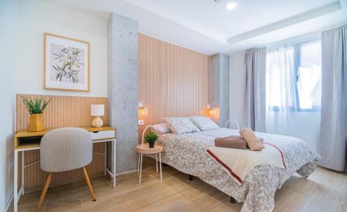a bedroom with a bed and a desk and a chair at CARTAGENAFLATS - San Diego Suites in Cartagena