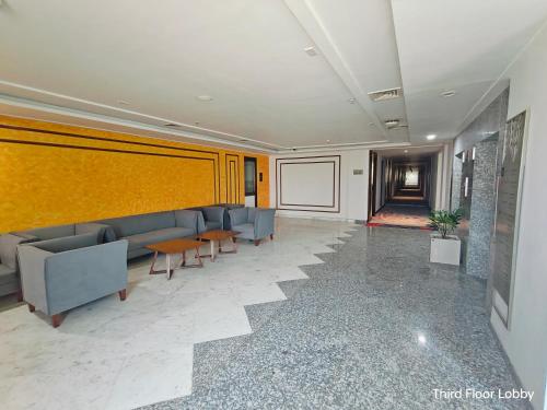 a lobby with couches and tables and a screen at Ramada by Wyndham Ahmedabad Narendra Modi Stadium Motera in Ahmedabad
