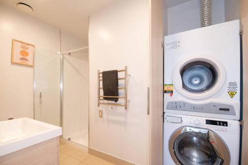 a washing machine and a washer in a bathroom at 180 Degrees Seaview and Harbor View 2 bedroom Apartment in Auckland