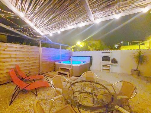 une terrasse avec une table de ping-pong et des chaises dans l'établissement Le 34 degrés sud - 2 chambres - jardinet et jacuzzi, à Thèzan-lès-Béziers