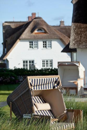 a suitcase sitting in the grass in front of a house at Strandvogtei Sylt in Rantum