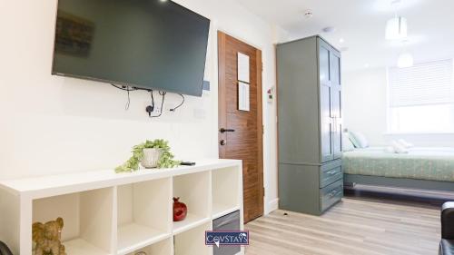 a living room with a tv on a wall at Old Silk Apartments - Luxury Studios, 1 & 2-beds in Coventry City Centre by COVSTAYS in Coventry