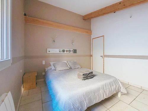 une chambre avec un lit avec des draps blancs et une fenêtre dans l'établissement Le 34 degrés sud - 2 chambres - jardinet et jacuzzi, à Thèzan-lès-Béziers