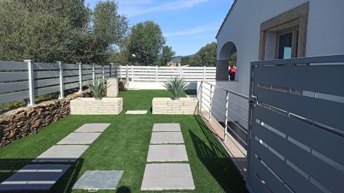 a backyard with a white fence and grass at Villa 21 in Budoni