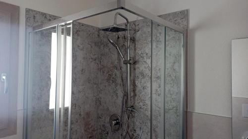 a shower with a glass door in a bathroom at Villa 21 in Budoni