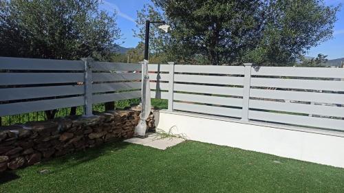 a white fence next to a stone wall at Villa 21 in Budoni
