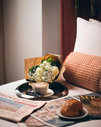 a table with a cup of coffee and a box of flowers at The Welbeck Hotel by IHG in London