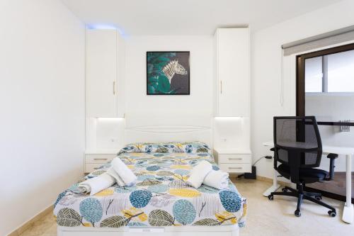 a bedroom with a bed and a desk and a chair at Apartamento con vistas al océano in Puerto de la Cruz