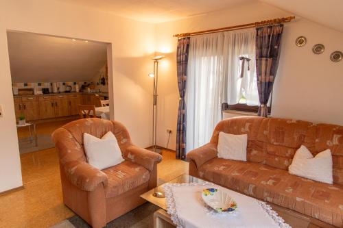 a living room with a couch and a chair at Ferienwohnung Werner in Warmensteinach