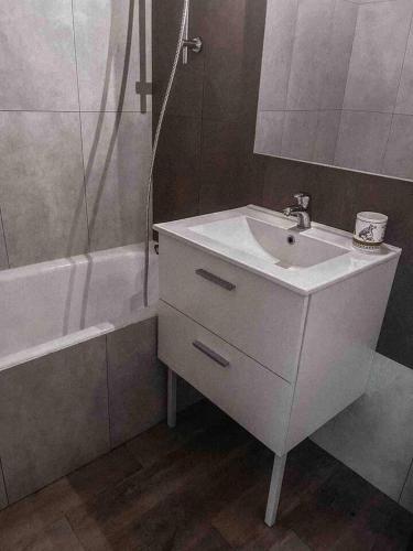 une salle de bain blanche avec un lavabo et une douche dans l'établissement Cosy appartement 50m from slopes 6 people, à Les Deux Alpes