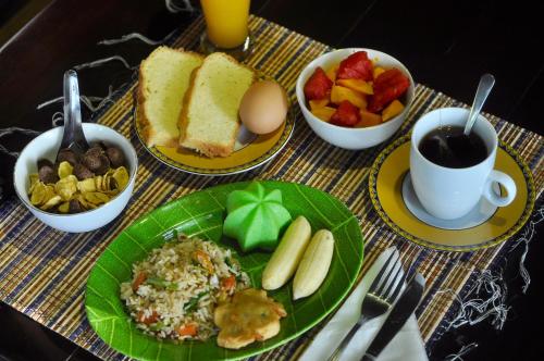 a table topped with plates of food and bowls of fruit at Raja Ampat Dive Resort in Tapokreng