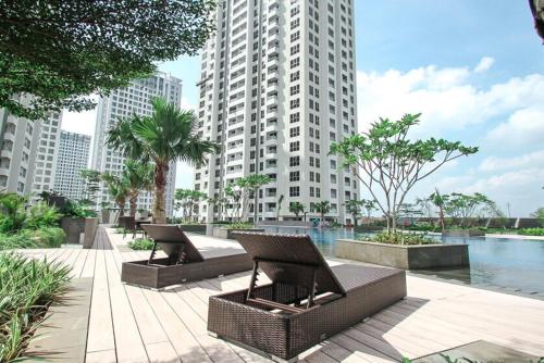 two wicker benches in a city with tall buildings at Spacious 2 Bedroom Apartment Near SMS Mall in Pumpangsineng
