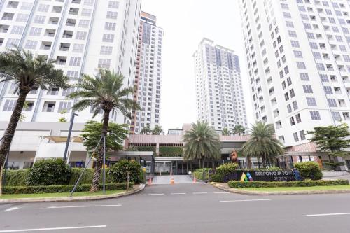 a parking lot with palm trees in front of tall buildings at Spacious 2 Bedroom Apartment Near SMS Mall in Pumpangsineng