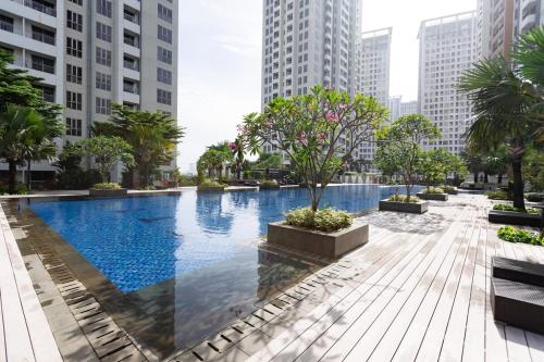 a large swimming pool in a city with tall buildings at Spacious 2 Bedroom Apartment Near SMS Mall in Pumpangsineng