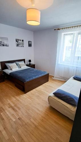 a bedroom with two beds and a large window at Apartament Mickiewicza in Rumia