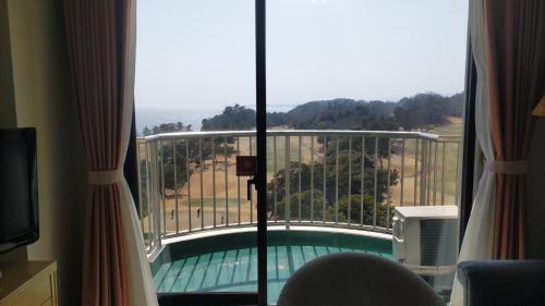 a room with a view of a swimming pool through a window at Onahama Ocean Hotel & Golf Club in Iwaki