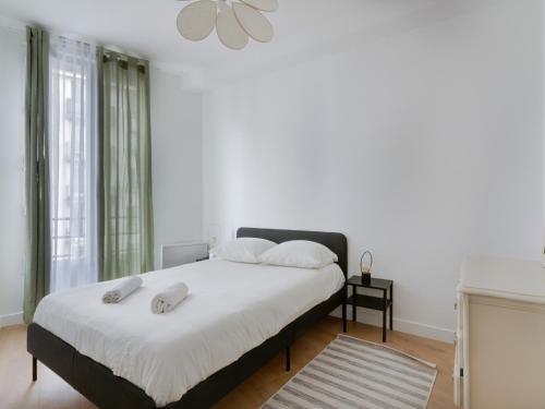 une chambre avec un lit avec deux serviettes dessus dans l'établissement La Pause Citadine, à Saint-Denis