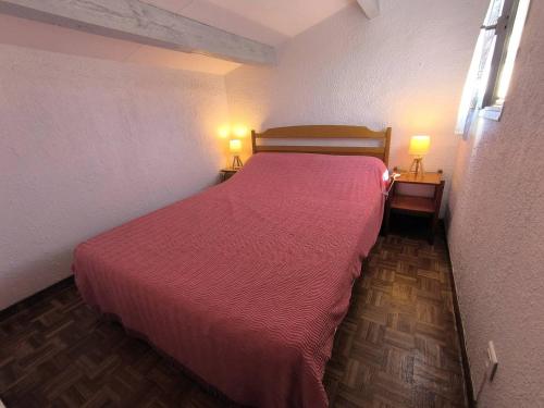 - une chambre avec un lit avec un couvre-lit rouge et deux lampes dans l'établissement 002 Mas du Soleil 332, au Cap d'Agde