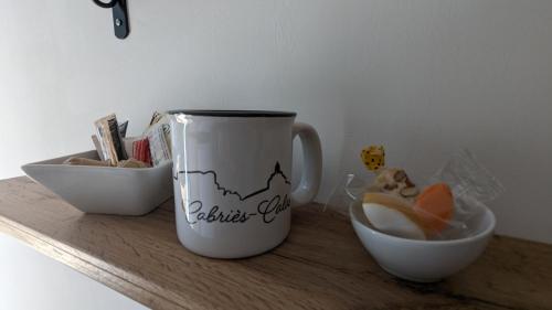 a coffee cup and a bowl on a wooden shelf at Studio cosy neuf calme -Parking Terrasse privée Piscine 5mn Gare TGV Aix et ZA Aix la Duranne 15 mn Aéroport Marseille in Cabriès