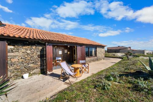a stone cottage with a table and chairs on a patio at The Nomad Apulia in Apúlia