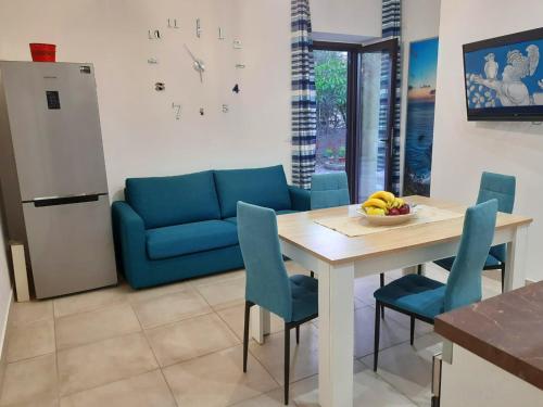 a kitchen with a table and a blue couch at Paradiso sul mare in Milazzo