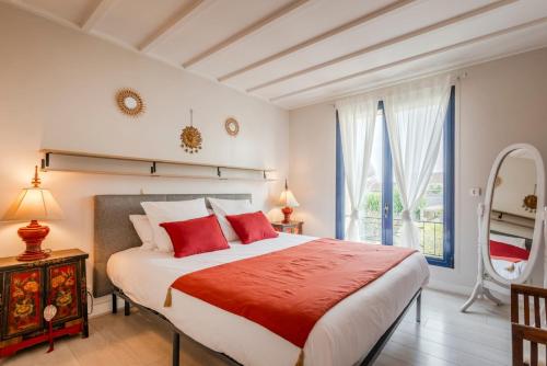 une chambre avec un grand lit avec des oreillers rouges dans l'établissement OIQIA • Prestige, à Barbery