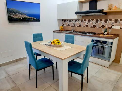 a kitchen with a wooden table and blue chairs at Paradiso sul mare in Milazzo