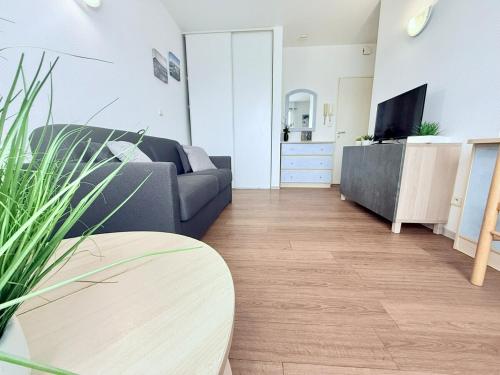 un salon avec un canapé et une télévision dans l'établissement 1741 - Roche-Étape, à Rochefort