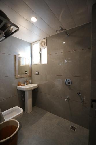 a bathroom with a shower and a toilet and a sink at Hotel Asian Comfort in Srinagar