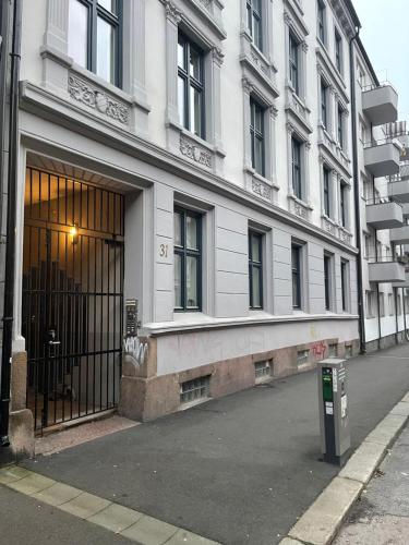 a large white building with a door on a street at Quiet apartment, trendy Grünerlokka in Oslo