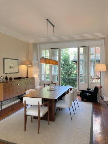 un salon avec une table et des chaises de salle à manger dans l'établissement House facing Roland Garros stadium - 5 bedrooms, à Boulogne-Billancourt
