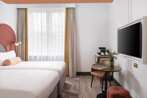 a hotel room with a bed and a tv at The Welbeck Hotel by IHG in London