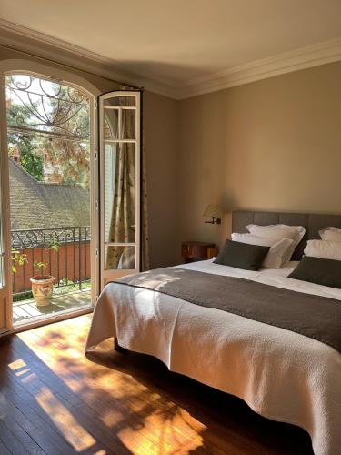 - une chambre avec un grand lit et une porte coulissante en verre dans l'établissement House facing Roland Garros stadium - 5 bedrooms, à Boulogne-Billancourt