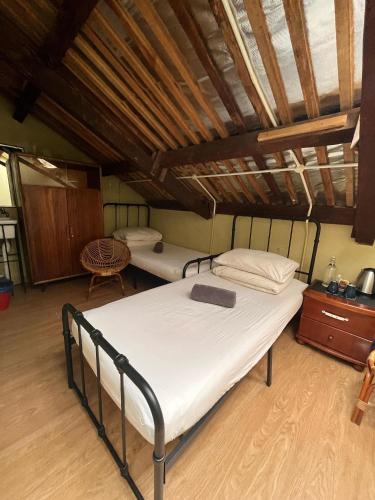 a bedroom with two beds in a attic at Chinatown Hostel by Mingle - Rooftop Private Jacuzzi with Bar in Kuala Lumpur