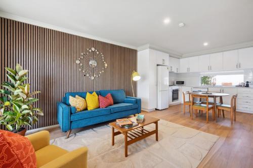a living room with a blue couch and a table at Happy Stays Classic Mid-Century Modern Escape in Perth
