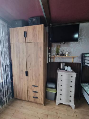 a bedroom with a wooden cabinet and a dresser with a tv at Privatzimmer Zur alten Salzstraße in Schnakenbek