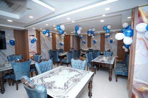 a banquet hall with blue and white balloons and tables at Hotel Asian Comfort in Srinagar