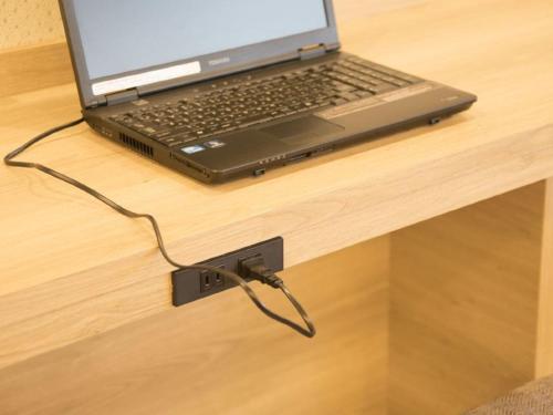 a laptop computer sitting on a table with a charger at Richmond Hotel Yamagata Ekimae in Yamagata
