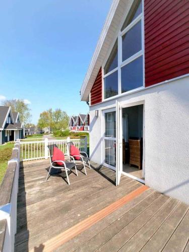 two chairs on a wooden deck next to a house at Ferienpark Bad Saarow in Bad Saarow