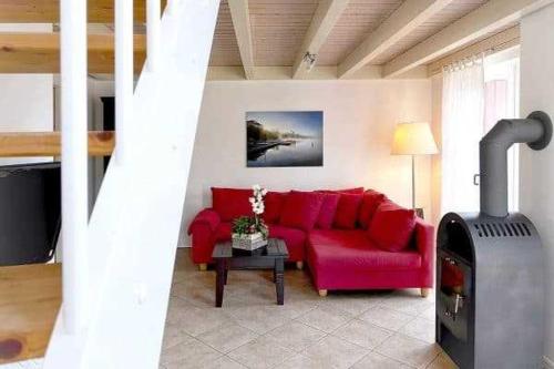 a living room with a red couch and a fireplace at Ferienpark Bad Saarow in Bad Saarow