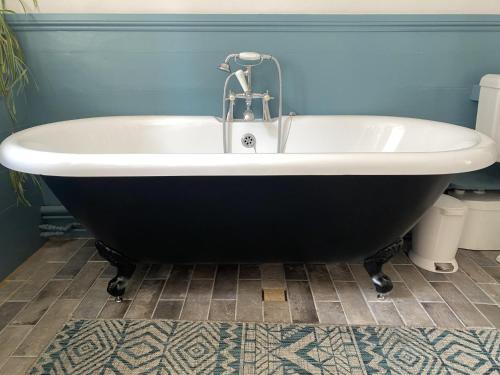 a black and white bath tub in a bathroom at The Totnes Guest House. Upstairs at Zappa's in Totnes