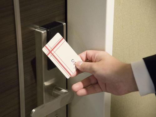 a person holding a credit card in a door at Richmond Hotel Yamagata Ekimae in Yamagata
