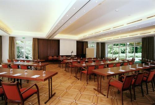 a large room with wooden tables and chairs at Parkhotel Am Glienberg by NP in Zinnowitz