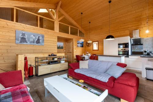 un salon avec un canapé rouge et une cuisine dans l'établissement El Cadi - Proche des Stations, à Font-Romeu