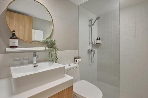 a bathroom with a toilet and a sink and a mirror at Somerset Sukhumvit 71 Bangkok in Bangkok