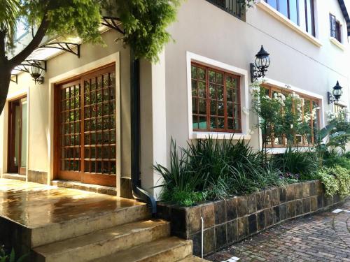 a building with two doors and some plants at Dunvegan Execu Lodge in Edenvale
