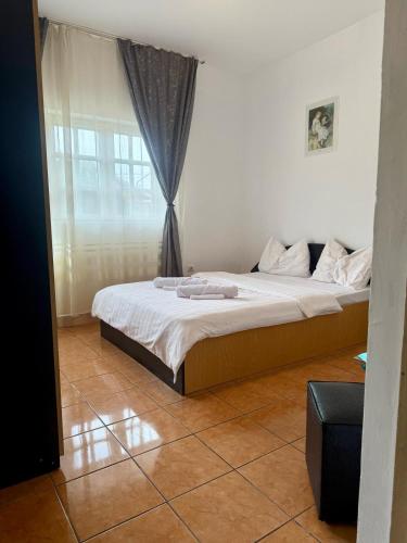 a bedroom with a large bed with a window at Casa Elenisse in 2 Mai