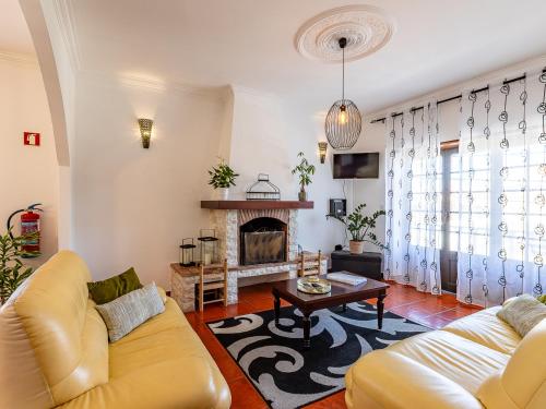 a living room with a couch and a fireplace at Nº57 House - Ribamar in Santo Isidoro